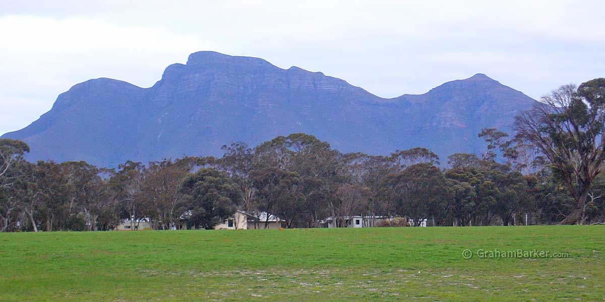 Bluff Knoll from the airstrip with glimpses of accommodation through the trees below. Stirling Range Retreat, Western Australia
